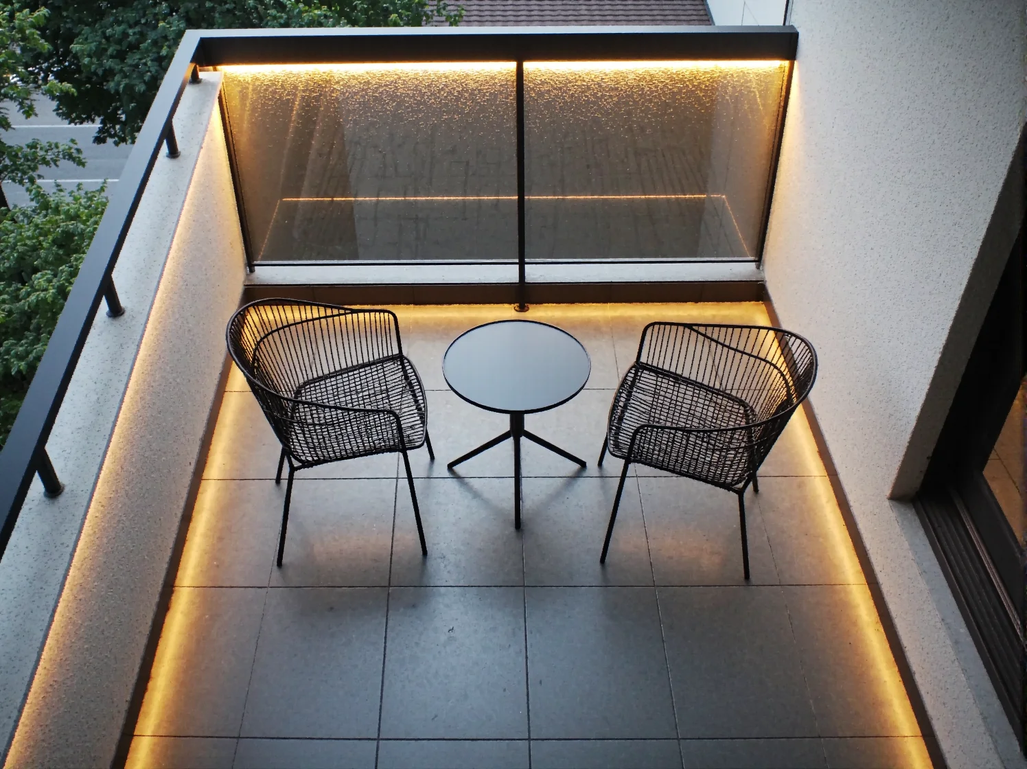 Szczegół aranżacji balkonu w stylu loft: połączenie betonu, metalu oraz czarnych i szarych akcentów.